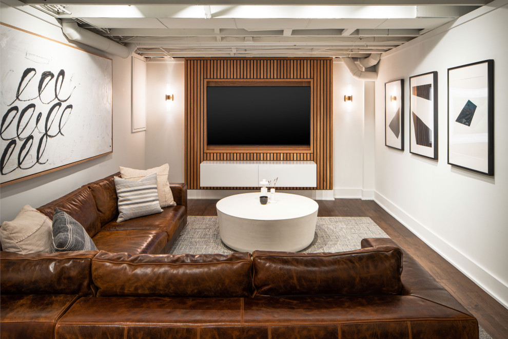 This is an example of a medium sized modern fully buried basement in Columbus with a home cinema, white walls, vinyl flooring, brown floors and wood walls.