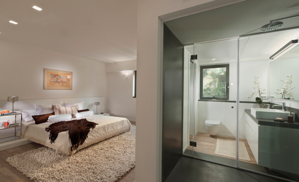 Photo of a contemporary bedroom in Other with white walls and light hardwood floors.