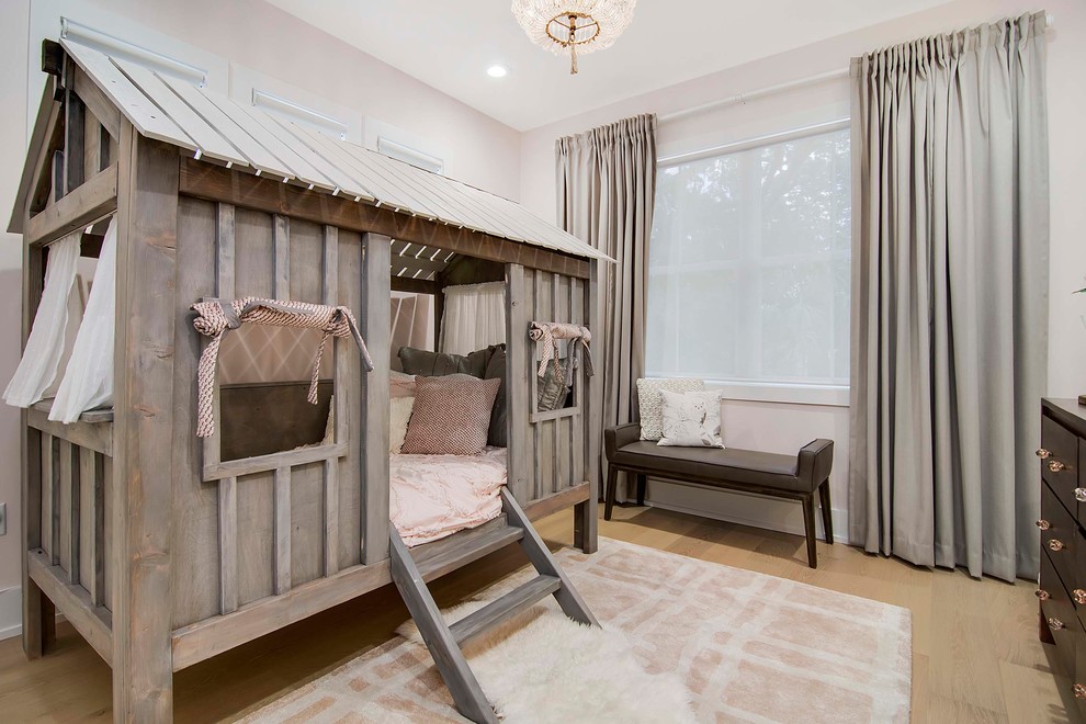 This is an example of a large beach style kids' bedroom for kids 4-10 years old and girls in Orlando with pink walls, light hardwood floors and beige floor.