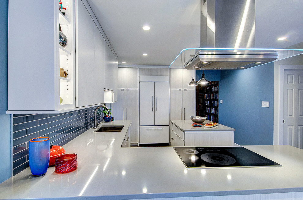 Inspiration for a mid-sized modern l-shaped eat-in kitchen in Philadelphia with an undermount sink, flat-panel cabinets, white cabinets, quartzite benchtops, blue splashback, glass tile splashback, panelled appliances, vinyl floors, with island, grey floor and grey benchtop.