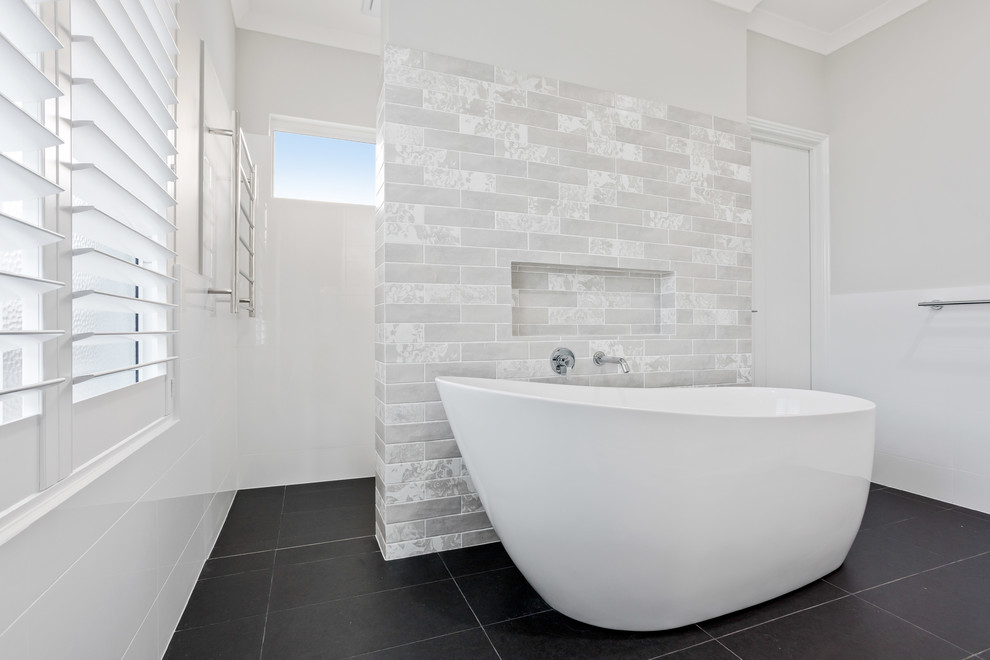 Design ideas for a mid-sized beach style master bathroom in Perth with shaker cabinets, white cabinets, a freestanding tub, an open shower, white tile, porcelain tile, white walls, porcelain floors, a drop-in sink, marble benchtops, grey floor and white benchtops.