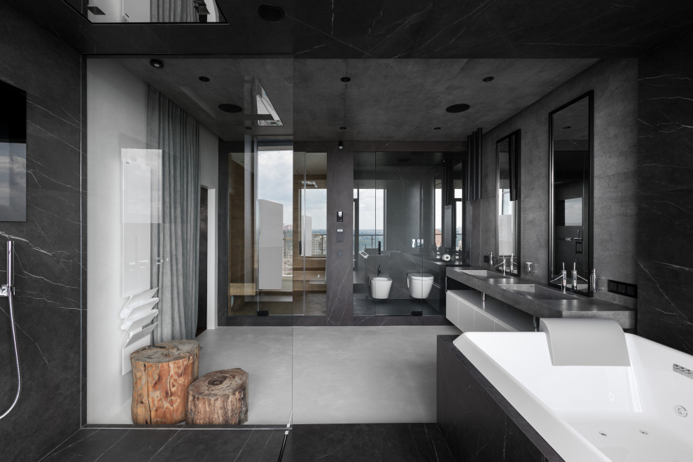 Cette image montre une salle d'eau grise et blanche urbaine de taille moyenne avec un placard à porte plane, des portes de placard blanches, un bain bouillonnant, une douche à l'italienne, WC suspendus, un carrelage gris, des dalles de pierre, un mur gris, un sol en carrelage de céramique, un lavabo intégré, un plan de toilette en granite, un sol gris, aucune cabine, un plan de toilette gris, meuble simple vasque, meuble-lavabo suspendu et un plafond décaissé.