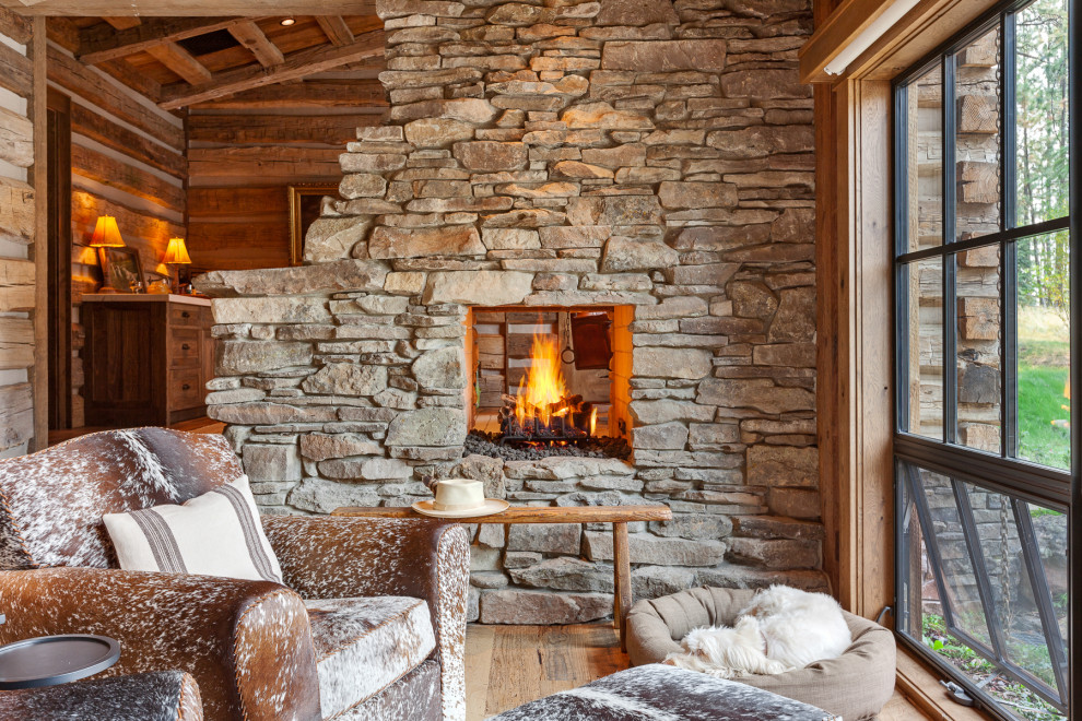 Идея дизайна: открытая гостиная комната в стиле рустика с фасадом камина из камня, сводчатым потолком и деревянными стенами