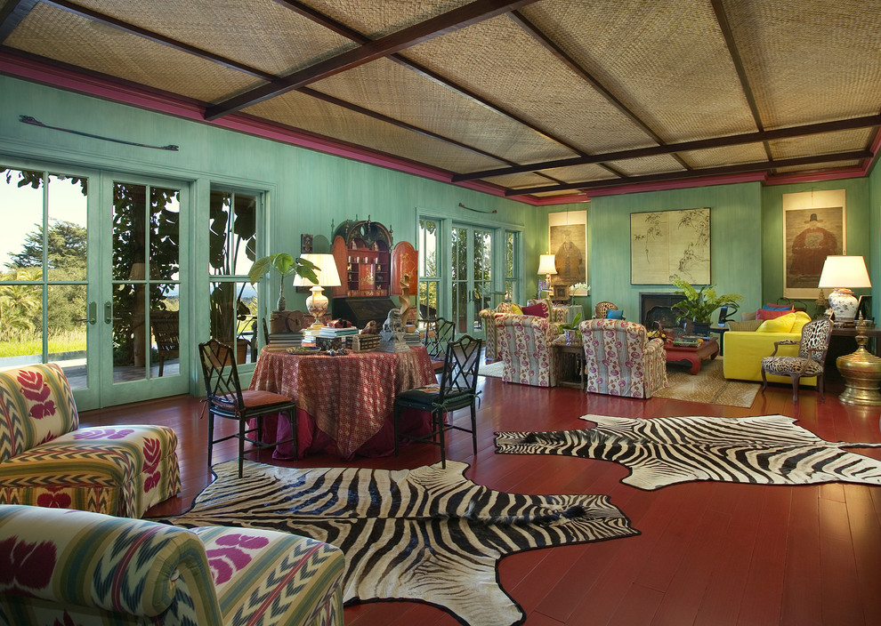 This is an example of an eclectic living room in Santa Barbara with green walls and red floor.