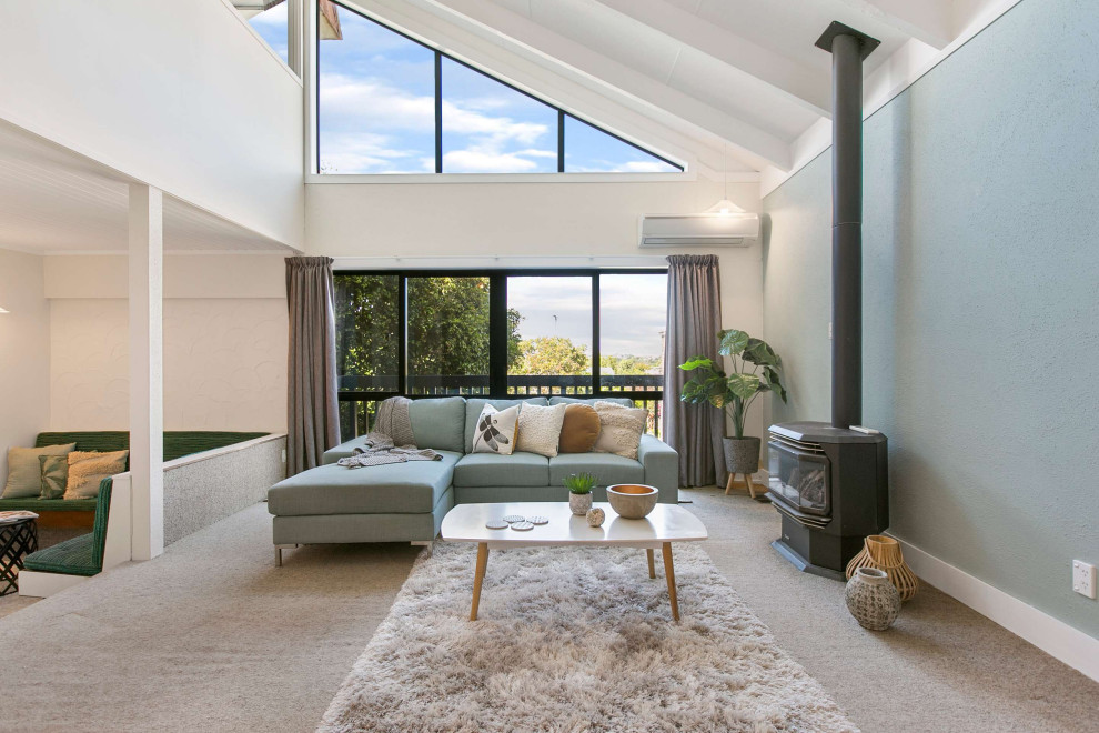 Inspiration for a Mid-sized transitional Loft-style living room in Auckland With Blue Walls, Carpet, a Wood Stove and Beige Floor.