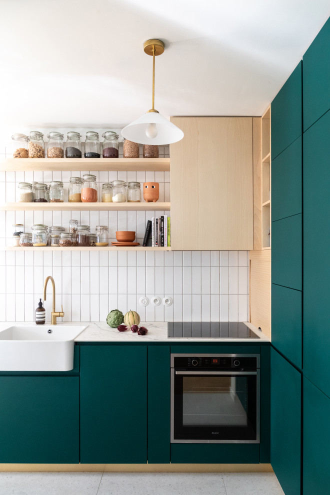 Inspiration for a medium sized modern l-shaped open plan kitchen in Paris with a single-bowl sink, beaded cabinets, green cabinets, tile countertops, white splashback, porcelain splashback, black appliances, ceramic flooring, an island, grey floors and white worktops.