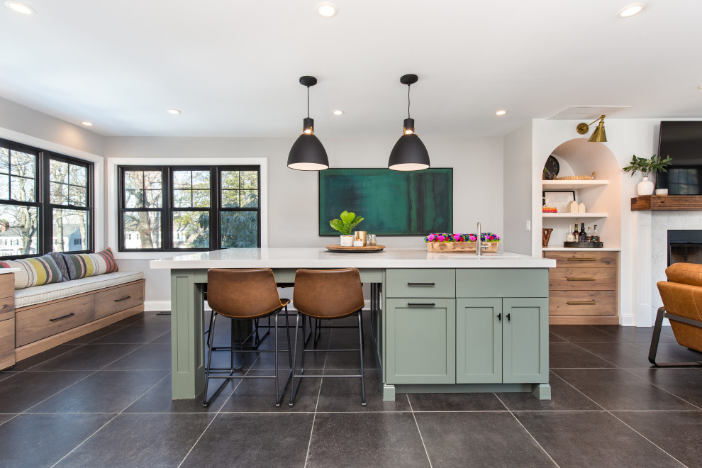 This is an example of a mid-sized transitional galley open plan kitchen in New York with an undermount sink, shaker cabinets, green cabinets, quartz benchtops, white splashback, ceramic splashback, stainless steel appliances, ceramic floors, with island, grey floor and white benchtop.