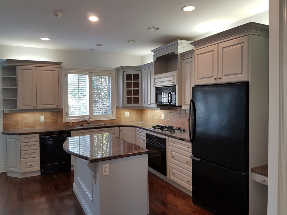 Mid-sized transitional l-shaped open plan kitchen in Toronto with raised-panel cabinets, white cabinets, granite benchtops, black appliances, dark hardwood floors, with island, a double-bowl sink, beige splashback, ceramic splashback and brown floor.
