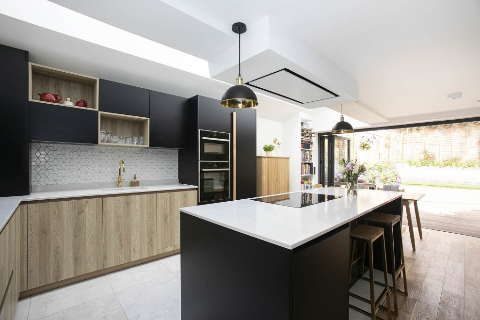 Design ideas for a small contemporary l-shaped open plan kitchen in London with an undermount sink, beaded inset cabinets, black cabinets, quartzite benchtops, white splashback, ceramic splashback, black appliances, ceramic floors, with island, multi-coloured floor, white benchtop and vaulted.