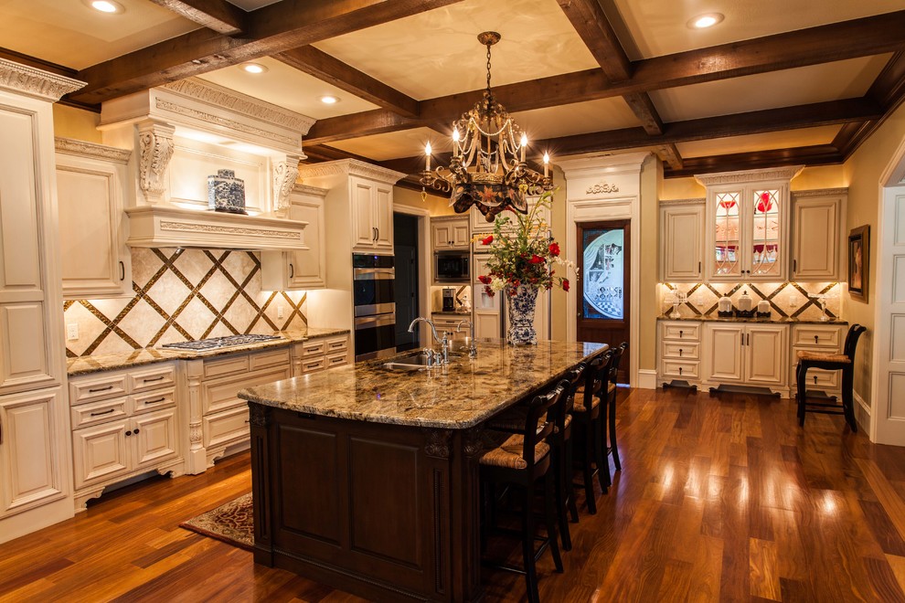 Example of a huge transitional u-shaped medium tone wood floor eat-in kitchen design with an undermount sink, raised-panel cabinets, white cabinets, granite countertops, metallic backsplash, stone tile backsplash, stainless steel appliances and an island