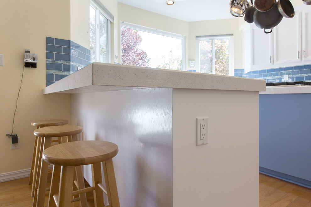 Modern u-shaped kitchen in Sacramento with an undermount sink, white cabinets, quartz benchtops and blue splashback.
