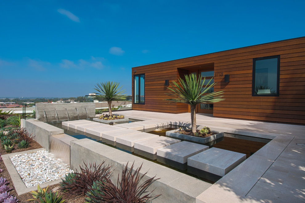 Design ideas for a contemporary front yard full sun garden in Orange County with a water feature and concrete pavers.