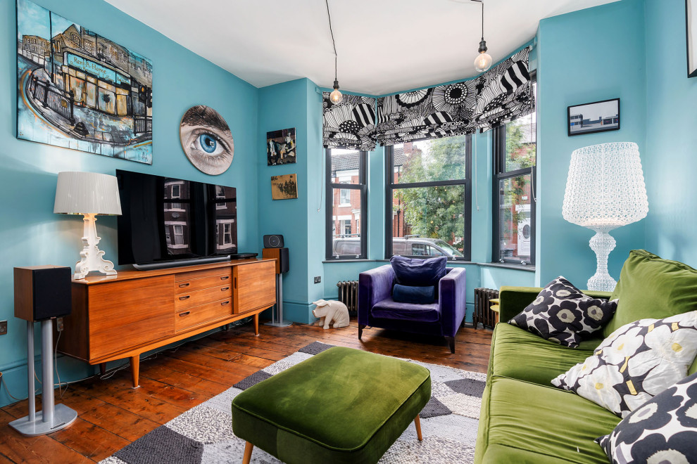 На фото: гостиная комната в стиле фьюжн с синими стенами, темным паркетным полом, отдельно стоящим телевизором и коричневым полом с