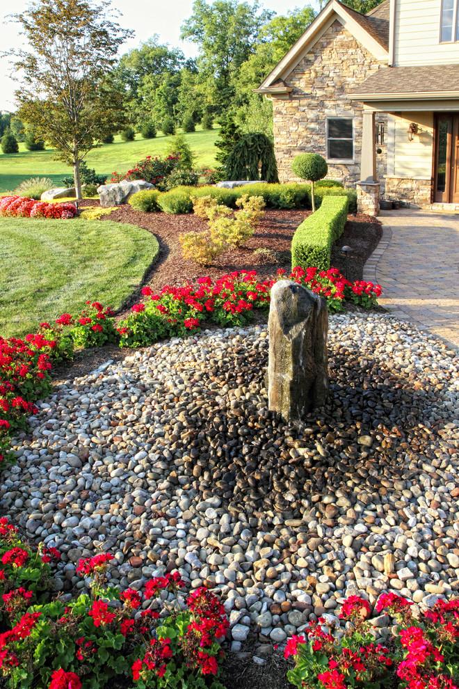 Design ideas for a traditional front yard full sun garden in Other with a water feature and river rock.