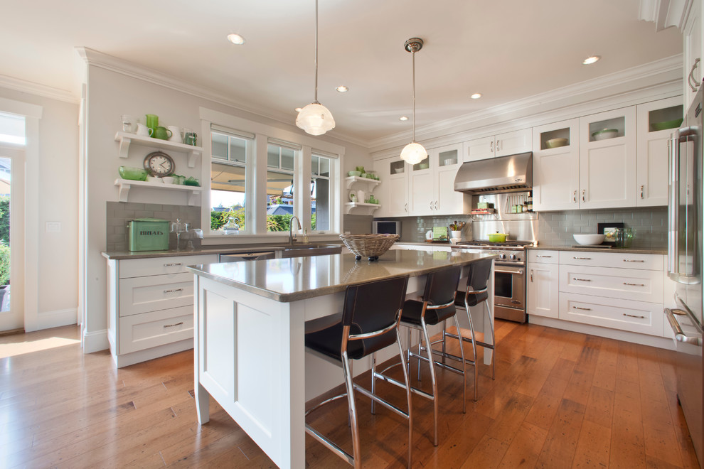 Inspiration for a traditional l-shaped kitchen in Vancouver with subway tile splashback, quartz benchtops, shaker cabinets, white cabinets, grey splashback and stainless steel appliances.