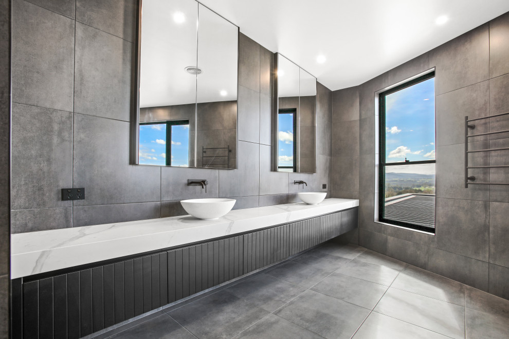 Design ideas for an expansive modern master wet room bathroom in Other with beaded inset cabinets, black cabinets, a one-piece toilet, gray tile, cement tile, grey walls, cement tiles, a vessel sink, engineered quartz benchtops, grey floor, an open shower, white benchtops, an enclosed toilet, a double vanity and a floating vanity.