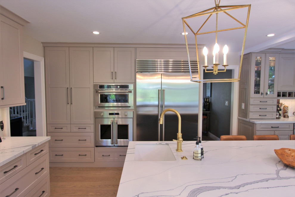 Exempel på ett stort klassiskt vit vitt kök, med en rustik diskho, luckor med infälld panel, beige skåp, bänkskiva i kvarts, vitt stänkskydd, rostfria vitvaror, mellanmörkt trägolv och en köksö