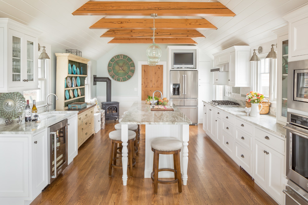 Design ideas for a large country galley separate kitchen in Boston with recessed-panel cabinets, white cabinets, marble benchtops, stainless steel appliances, medium hardwood floors, brown floor, grey splashback, subway tile splashback, with island and an undermount sink.