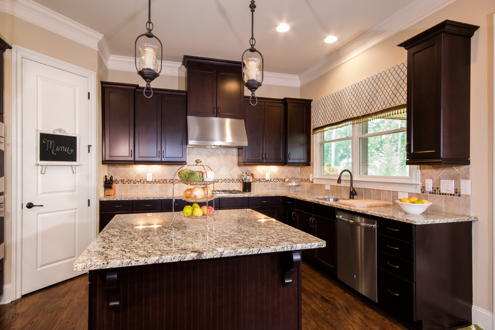 Photo of a mid-sized traditional u-shaped open plan kitchen in Atlanta with a double-bowl sink, shaker cabinets, dark wood cabinets, granite benchtops, beige splashback, mosaic tile splashback, stainless steel appliances, medium hardwood floors and with island.