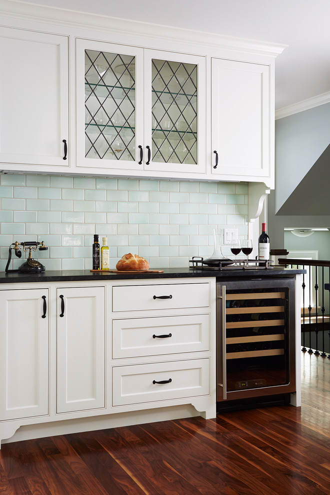 Example of a mid-sized transitional l-shaped dark wood floor enclosed kitchen design in Minneapolis with beaded inset cabinets, white cabinets, blue backsplash, ceramic backsplash, an undermount sink, quartzite countertops, stainless steel appliances and an island