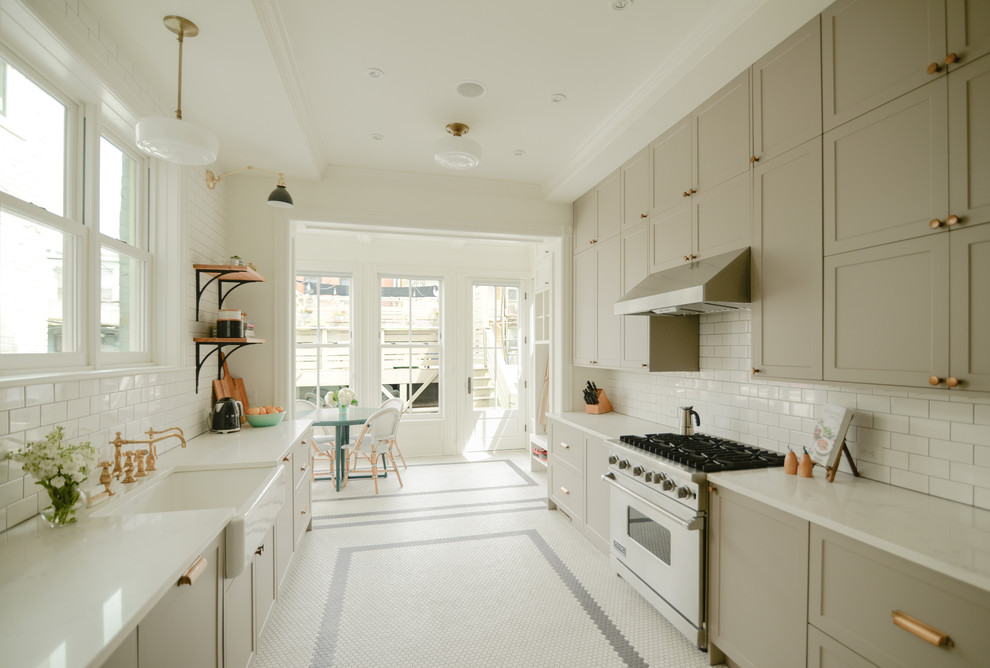 Mid-sized traditional galley eat-in kitchen in DC Metro with a farmhouse sink, recessed-panel cabinets, beige cabinets, quartz benchtops, white splashback, subway tile splashback, stainless steel appliances, porcelain floors, no island, white floor and white benchtop.