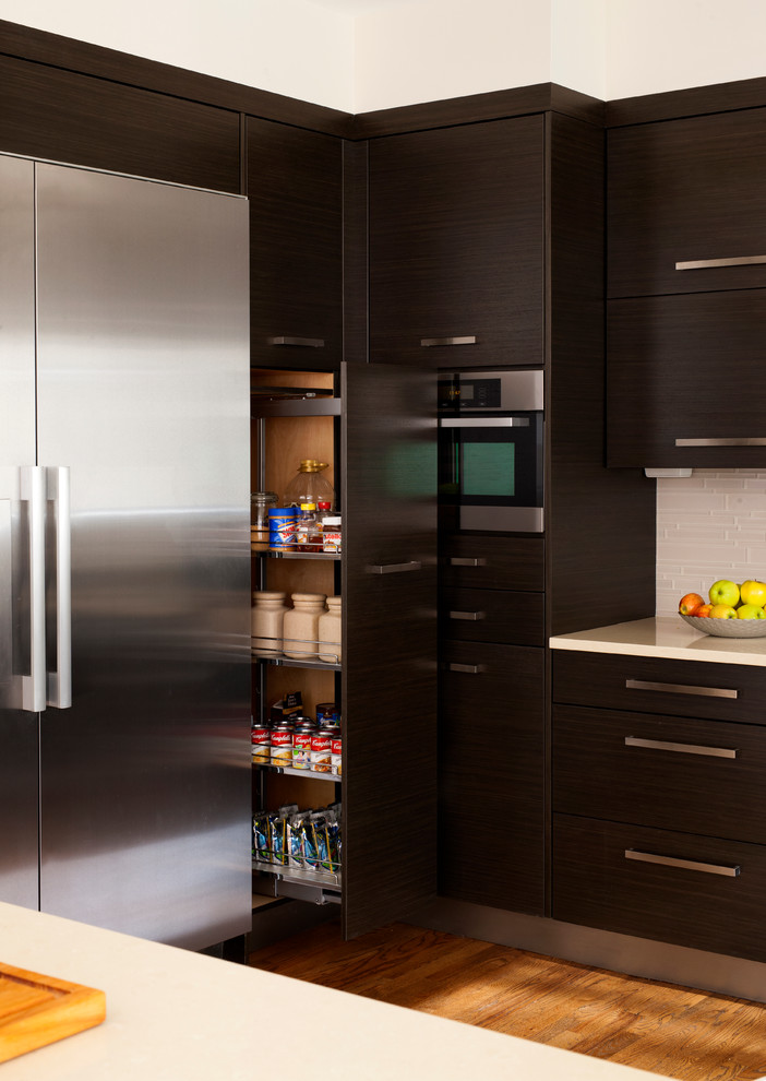 Mid-sized transitional u-shaped medium tone wood floor and brown floor eat-in kitchen photo in DC Metro with an undermount sink, flat-panel cabinets, white backsplash, stainless steel appliances, a peninsula, dark wood cabinets, quartz countertops and glass tile backsplash