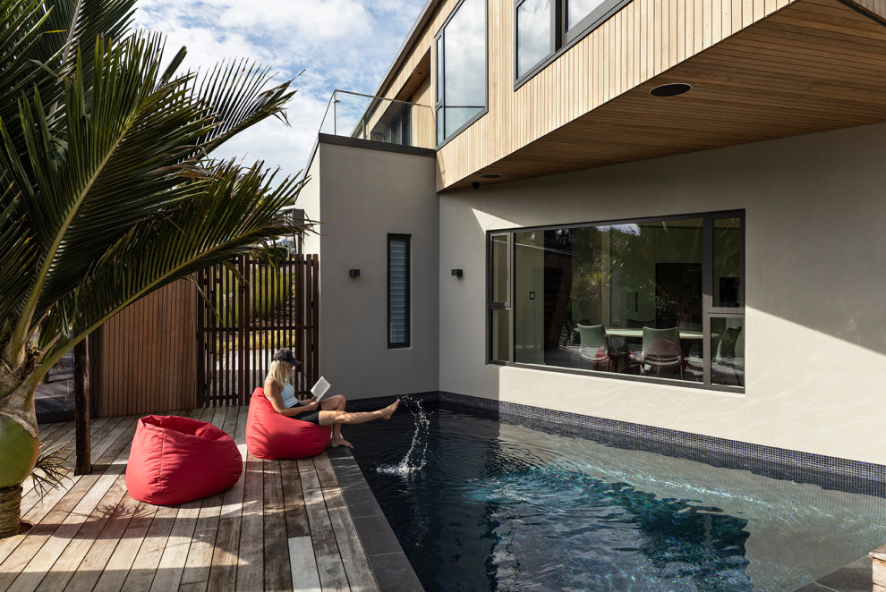 Foto de casa de la piscina y piscina alargada costera de tamaño medio a medida en patio delantero con entablado
