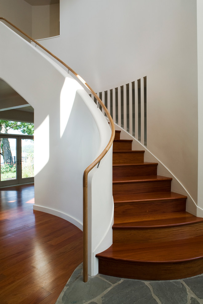 This is an example of a contemporary wood curved staircase in Baltimore with wood risers.