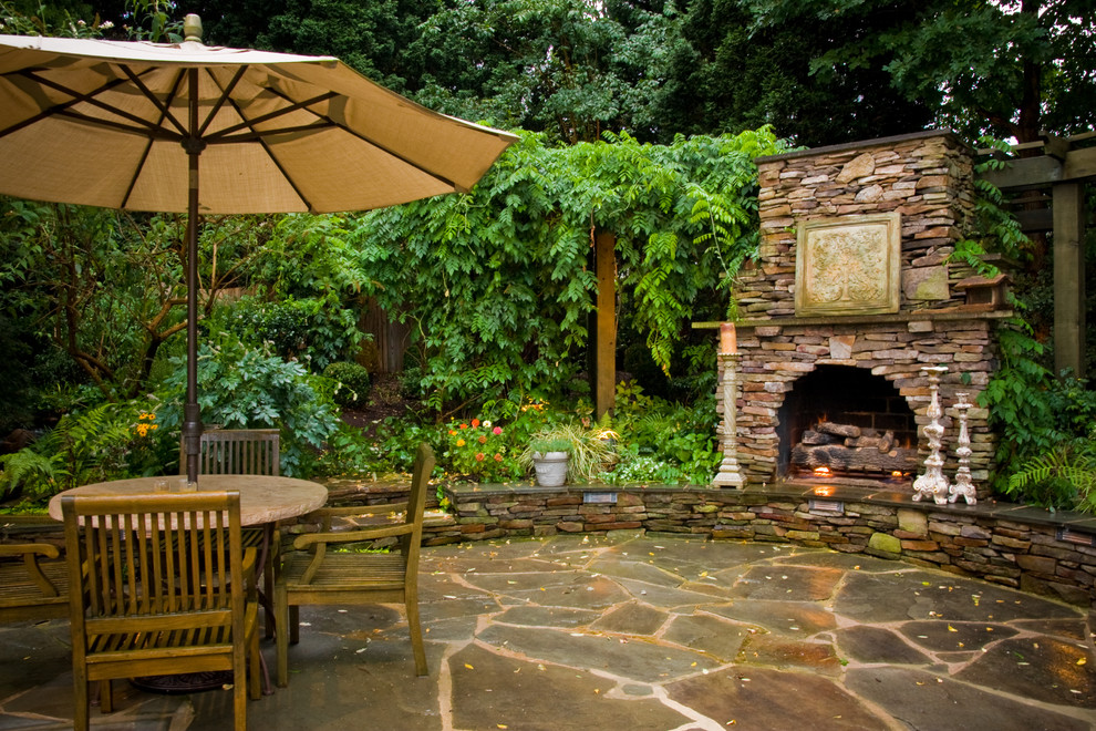 Mid-sized transitional backyard patio in Charlotte with a fire feature, natural stone pavers and a pergola.