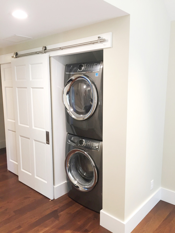 Small transitional single-wall laundry cupboard in Detroit with beige walls and a concealed washer and dryer.