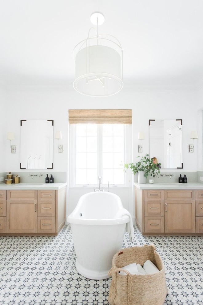 This is an example of a large transitional master bathroom in Salt Lake City with white walls, shaker cabinets, light wood cabinets, a freestanding tub, an alcove shower, white tile, ceramic floors, a drop-in sink, multi-coloured floor and a hinged shower door.