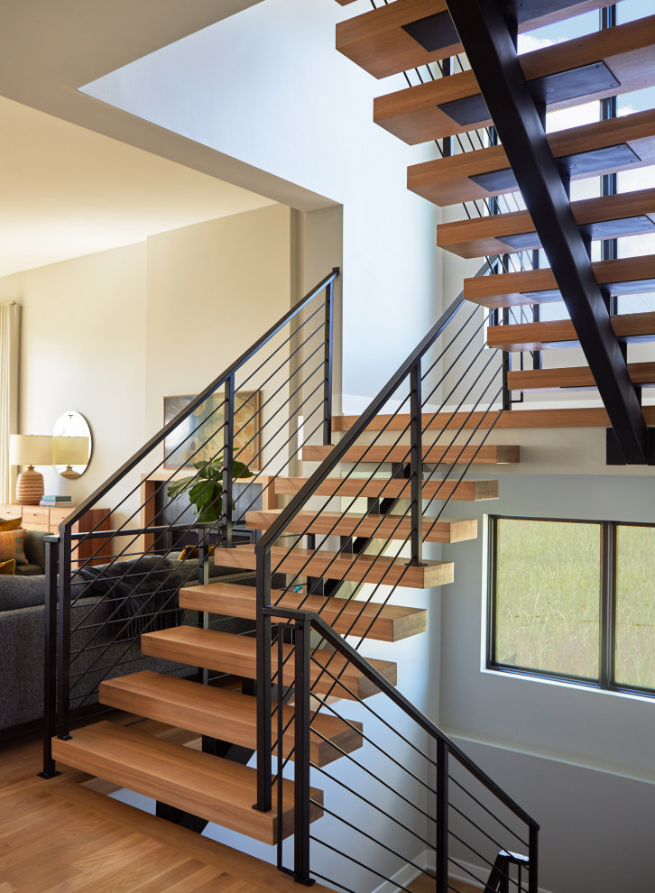 Photo of a midcentury wood floating staircase in Chicago with open risers and metal railing.