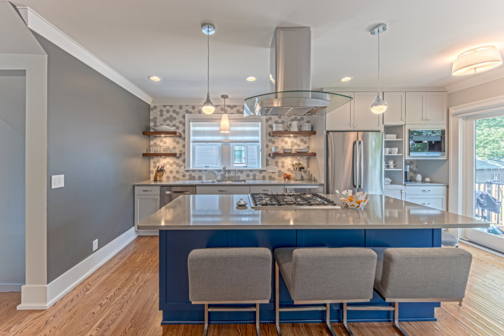 This is an example of a modern single-wall eat-in kitchen in Minneapolis with an undermount sink, shaker cabinets, white cabinets, quartzite benchtops, grey splashback, mosaic tile splashback, stainless steel appliances, medium hardwood floors, with island, brown floor and grey benchtop.