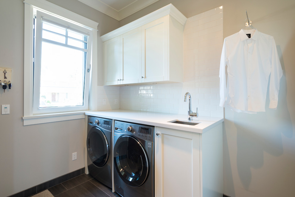 Inspiration for a mid-sized traditional single-wall dedicated laundry room in Vancouver with an undermount sink, shaker cabinets, white cabinets, quartz benchtops, grey walls, porcelain floors and a side-by-side washer and dryer.