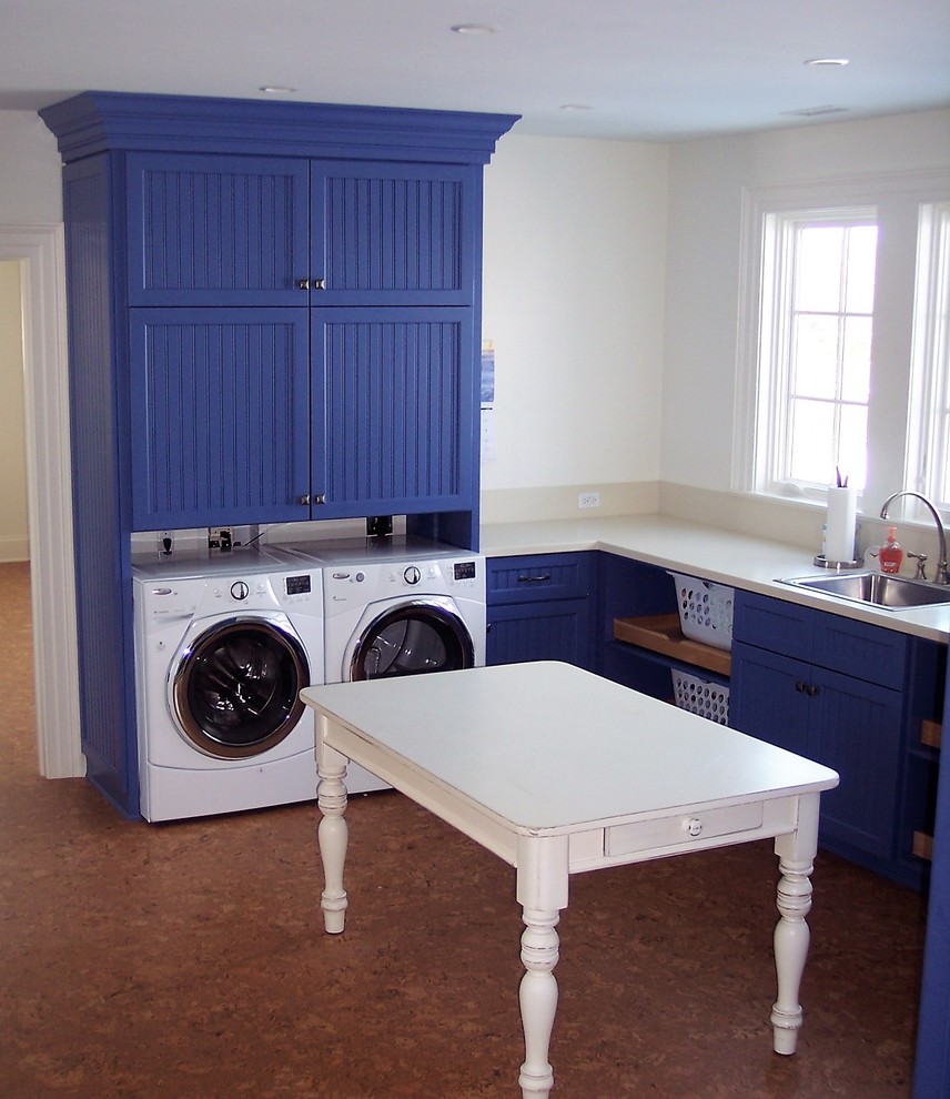 This is an example of a large country dedicated laundry room in Baltimore with shaker cabinets, blue cabinets, white walls, cork floors and a side-by-side washer and dryer.