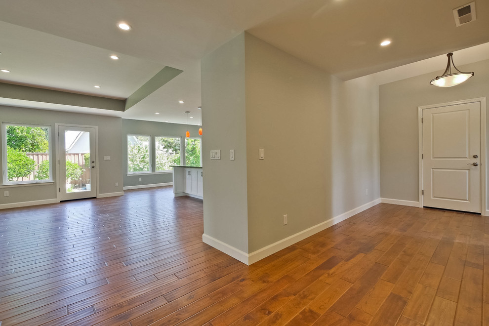 This is an example of a large contemporary front door in San Francisco with beige walls, light hardwood floors, a single front door, a white front door and brown floor.