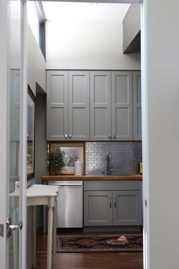 This is an example of a mid-sized midcentury galley kitchen pantry in Other with an undermount sink, wood benchtops and medium hardwood floors.