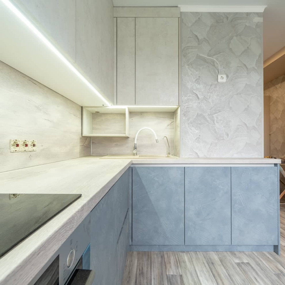 Большая угловая кухня в синем и белом цвете с фасадами под камень