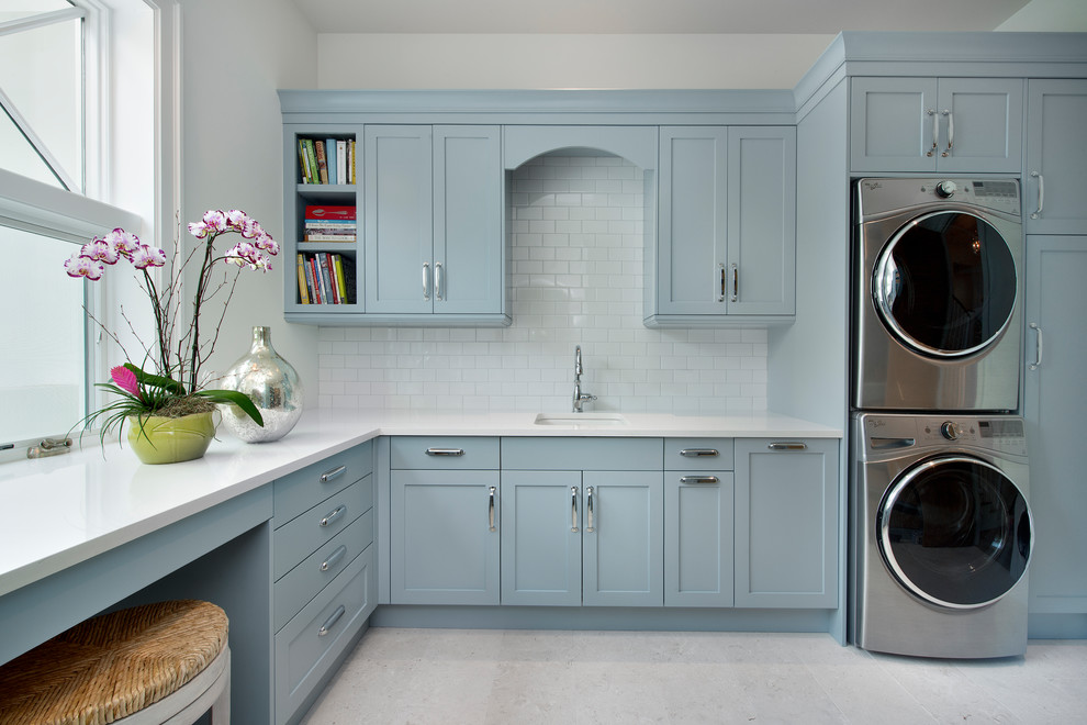 Design ideas for a large beach style laundry room in Other with an undermount sink, shaker cabinets, grey cabinets, quartz benchtops, white walls, a stacked washer and dryer, white floor and white benchtop.