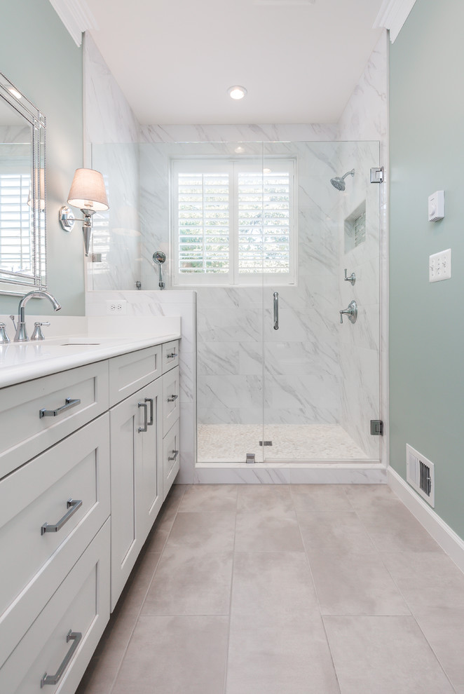 Photo of a small transitional master bathroom in DC Metro with shaker cabinets, grey cabinets, an alcove shower, a two-piece toilet, white tile, porcelain floors, an undermount sink, engineered quartz benchtops, beige floor, a hinged shower door, marble, grey walls and white benchtops.