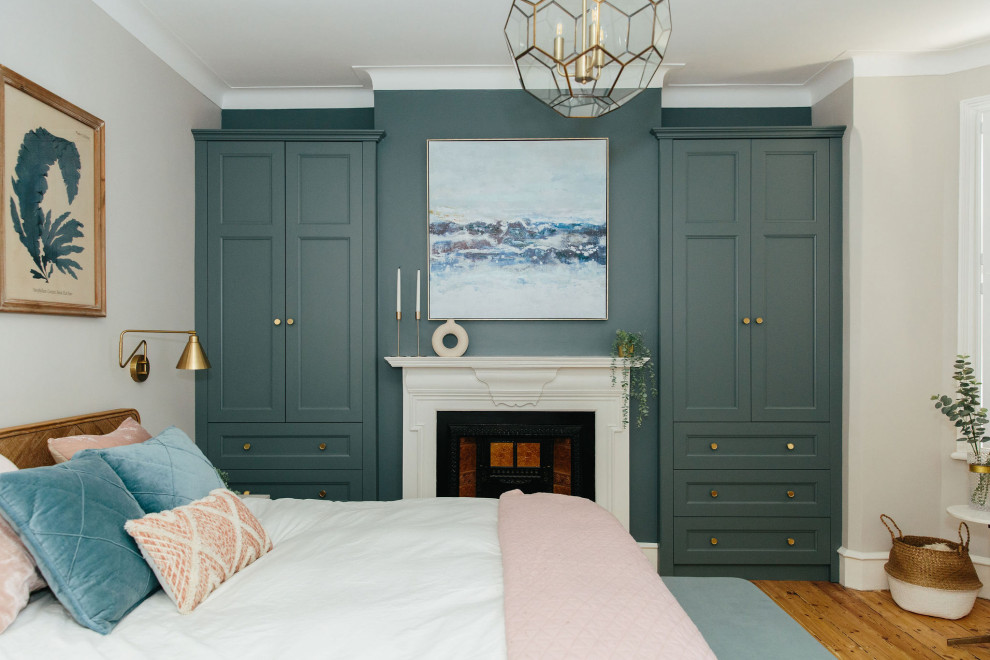 Идея дизайна: хозяйская спальня среднего размера в классическом стиле с белыми стенами, паркетным полом среднего тона, стандартным камином и коричневым полом