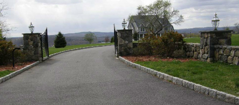 Design ideas for a large traditional full sun driveway in New York with natural stone pavers.