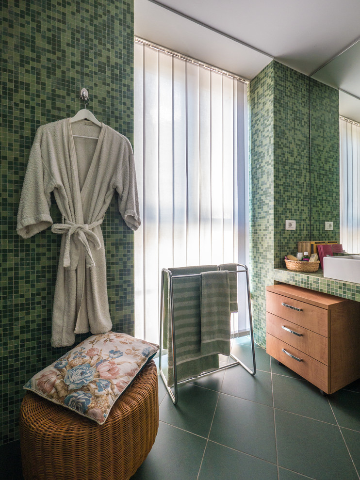 Small contemporary master bathroom in Milan with flat-panel cabinets, light wood cabinets, an alcove shower, a two-piece toilet, green tile, mosaic tile, green walls, ceramic floors, a trough sink, tile benchtops, green floor, a hinged shower door and green benchtops.