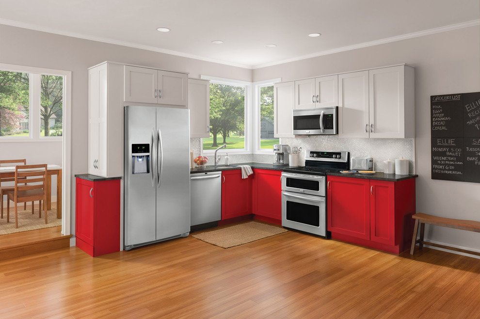 Mid-sized transitional l-shaped eat-in kitchen in New York with an undermount sink, recessed-panel cabinets, red cabinets, soapstone benchtops, white splashback, mosaic tile splashback, stainless steel appliances, medium hardwood floors and no island.