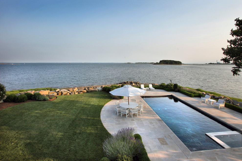 Large contemporary backyard rectangular lap pool in New York with a water feature and tile.