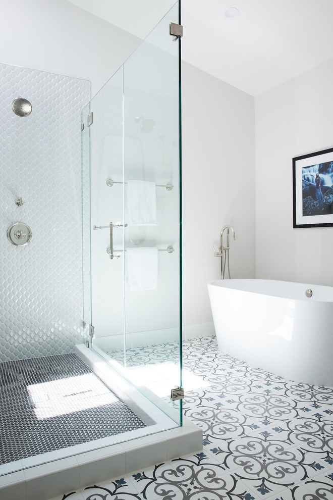 This is an example of a transitional master bathroom in San Francisco with flat-panel cabinets, a freestanding tub, white walls, porcelain floors, an undermount sink, marble benchtops, multi-coloured floor, a hinged shower door, grey cabinets, white tile and ceramic tile.