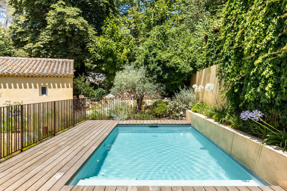 Design ideas for a small mediterranean front yard pool in Other with decking.