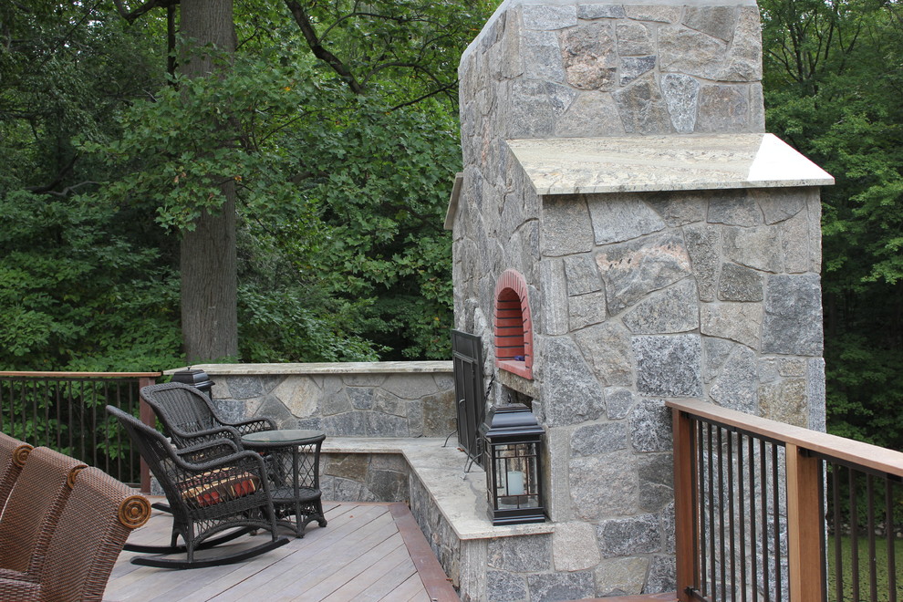 Example of a large transitional backyard deck design in Bridgeport with a fire pit and no cover