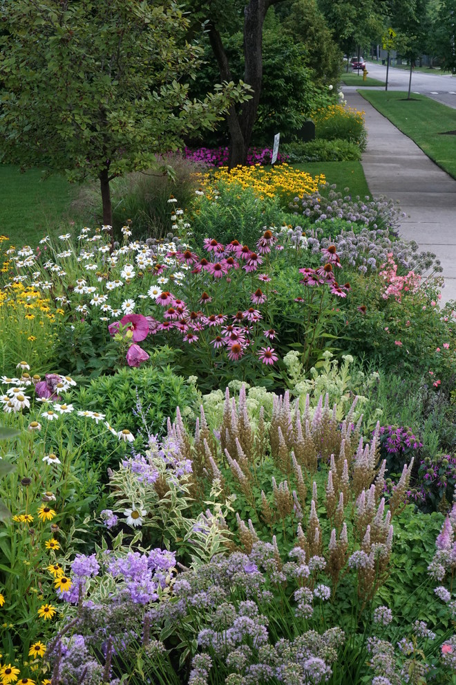 Photo of a large traditional partial sun front yard stone landscaping in Chicago.