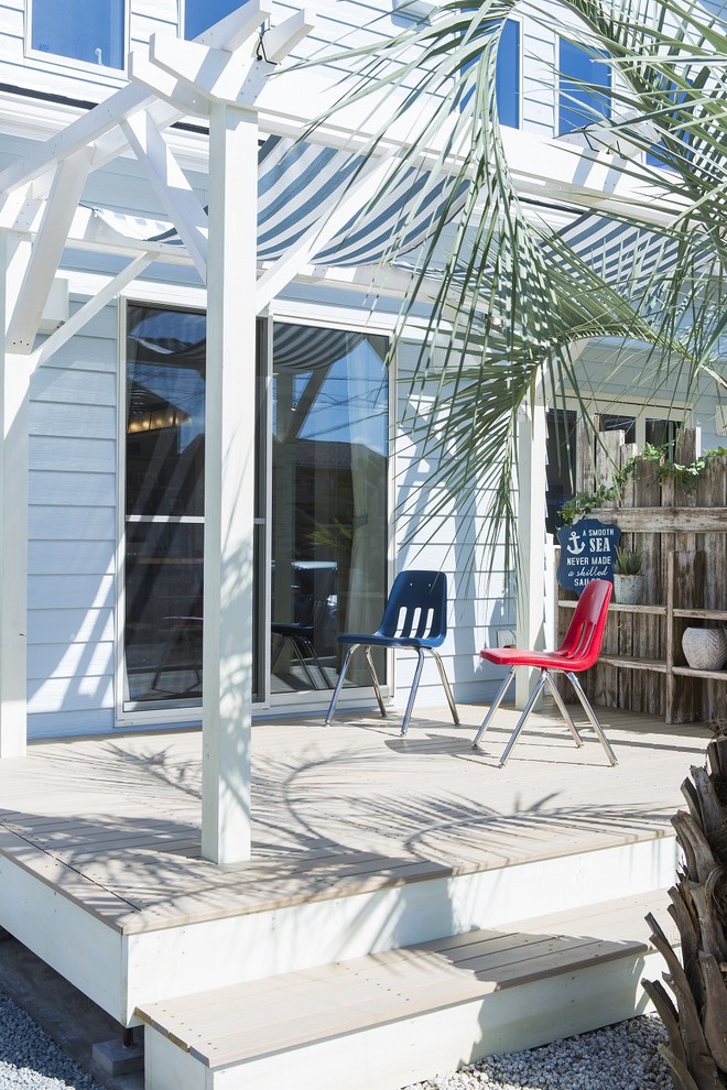 This is an example of a beach style side yard deck in Other with an awning.